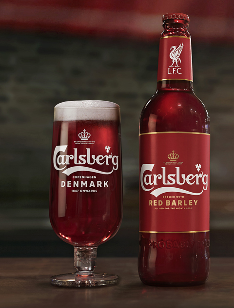 carlsbergs red barley beer in a glass and bottle standing on a table